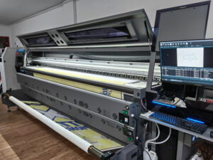 Custom flag printing on a wide-format digital press feeding printed fabric