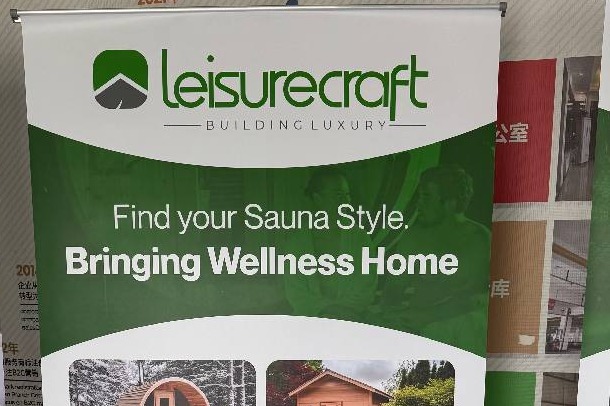 Roll-up banner stand carrying a client's sauna product range at an exhibition