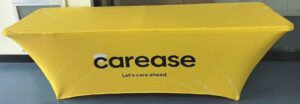 Yellow 180 gsm stretch table cover printed with a client logo on an 8 ft exhibition table