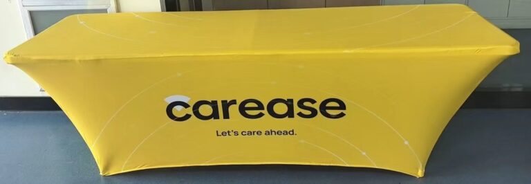 Yellow 180 gsm stretch table cover printed with a client logo on an 8 ft exhibition table